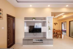 a living room with a flat screen tv on a wall at Elite Peak Serviced Apartments in Bangalore