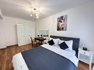 ein Schlafzimmer mit einem Bett und einem Tisch darin in der Unterkunft Cozy Apartments at Maurer Residence Brasov in Braşov