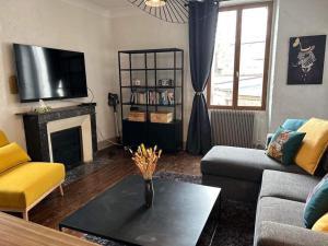 un salon avec une cheminée et une télévision dans l'établissement 4 Pièces, 70m² en centre-ville, à Bourges