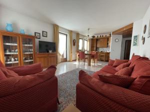 ein Wohnzimmer mit zwei roten Sofas und einer Küche in der Unterkunft 008 Quadrilocale, Pinzolo in Pinzolo