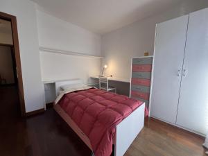 a bedroom with a bed with a red blanket at 008 Quadrilocale, Pinzolo in Pinzolo