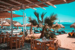 a restaurant on the beach with tables and chairs at Paradise Beach Resort in Paradise Beach