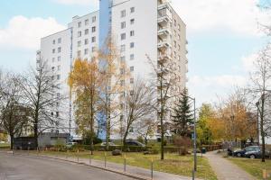 een straat voor een hoog wit gebouw bij Służew 405B Apartment by BookingHost in Warschau