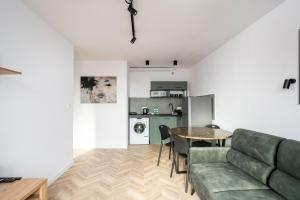 een woonkamer met een bank en een tafel bij Służew 405B Apartment by BookingHost in Warschau