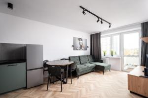 een woonkamer met een bank en een tafel bij Służew 405B Apartment by BookingHost in Warschau