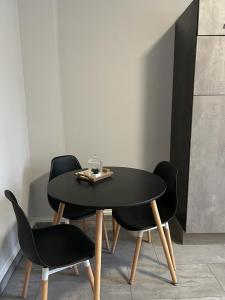 Essen的住宿－Sia Apartments Hotel，一张黑色桌子,上面有两把椅子和盘子