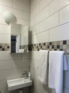 uma casa de banho com lavatório, espelho e toalhas em Sia Apartments Hotel em Essen