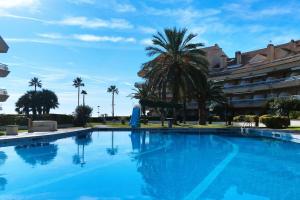 a large blue swimming pool in front of a building at Marítim II Primera línea de mar en St Antoni de Calonge in Sant Antoni de Calonge