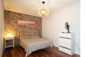 a bedroom with a bed and a brick wall at Apartamento Pinbal in Haro