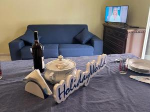 una mesa con una botella de vino y un mantel en La Baia Di Tindari by Holiday World, en Oliveri