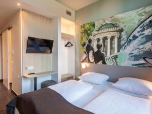 1 dormitorio con 1 cama y una pintura en la pared en B&B Hotel München-Trudering en Múnich