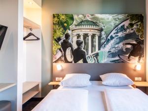 ein Schlafzimmer mit einem großen Gemälde über einem Bett in der Unterkunft B&B Hotel München-Trudering in München