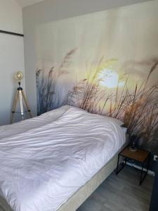ein Schlafzimmer mit einem weißen Bett und einem Gemälde an der Wand in der Unterkunft Het Haerman in De Lutte