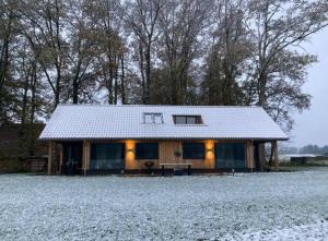 eine Hütte auf einem Feld mit Schnee auf dem Boden in der Unterkunft Het Haerman in De Lutte