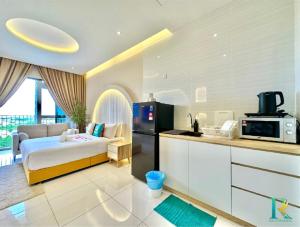 a room with a kitchen with a bed and a microwave at Sky Trees by Rentradise in Johor Bahru