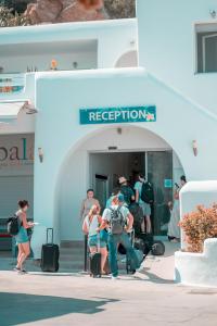 a group of people walking into a building with luggage at Paradise Beach Resort in Paradise Beach