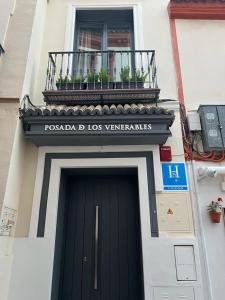 ein Gebäude mit einer schwarzen Tür und einem Balkon in der Unterkunft Posada de los Venerables in Sevilla