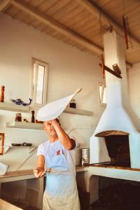 a woman wearing a chefs hat in a kitchen with an oven at Paradise Beach Resort in Paradise Beach