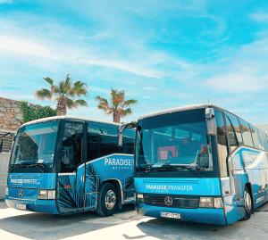 two buses parked next to each other in a parking lot at Paradise Beach Resort in Paradise Beach