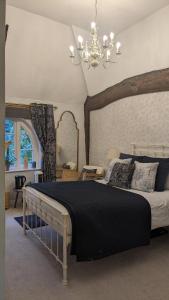 um quarto com uma cama grande e um lustre em Old Rectory House & Bedrooms em Redditch
