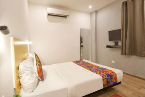 a small bedroom with a bed and a tv at FabHotel Golden World in Ghaziabad