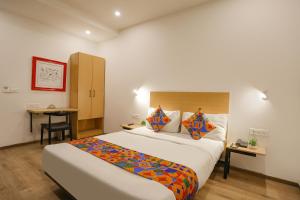 a hotel room with a bed and a desk at FabHotel Golden World in Ghaziabad