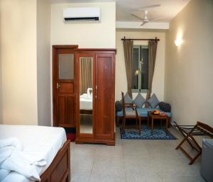a bedroom with a bed and a couch and a table at Mango Hill La Serene Puducherry in Pūrnānkuppam