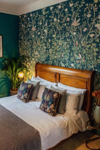 a bedroom with a bed with a floral wallpaper at Old Rectory House & Bedrooms in Redditch