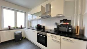 a kitchen with white cabinets and a black counter top at FeWo in Neumünster in Neumünster