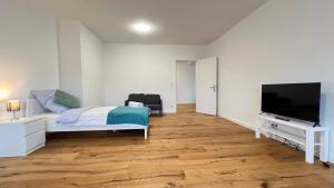 een kamer met een bed en een flatscreen-tv bij FeWo in Neumünster in Neumünster
