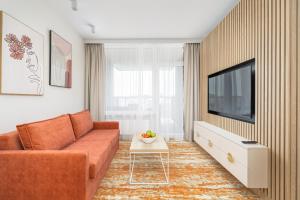 uma sala de estar com um sofá e uma televisão em Rent like home- Elegant Apartments with Balcony em Międzyzdroje