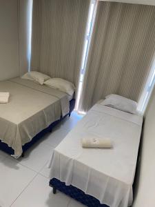 two beds sitting next to each other in a room at Pousada Terra Bela in Juazeiro do Norte
