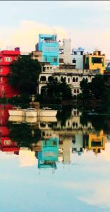 un reflejo de un edificio en un cuerpo de agua en Antariksh, en Udaipur