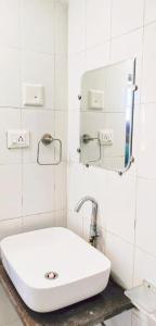 Baño blanco con lavabo y espejo en Antariksh, en Udaipur