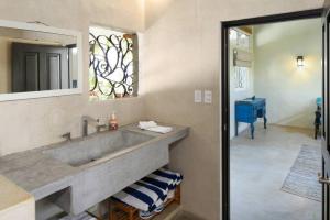 a bathroom with a sink and a mirror at Entire Tocayo Steps to Beach and Surf 4BD Condo with Master Suite in Sayulita +17 photos
