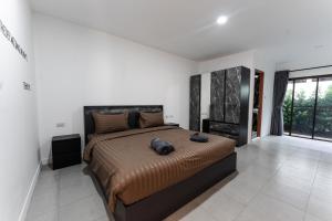 a bedroom with a large bed in a white room at Apollo Hotel Chalong in Ban Suan