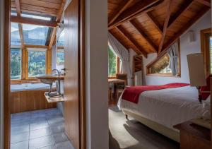 a bedroom with a bed and a bathroom with a tub at El Muelle by DOT Boutique in Villa La Angostura +28 photos