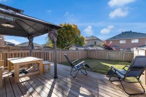 a deck with a table and chairs and an umbrella at Luxury 3BR - 10 Min to Wonderland - Monthly Rental in Vaughan