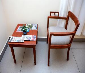 a table with a chair and a table with a plant on it at Mango Hill La Serene Puducherry in Pūrnānkuppam