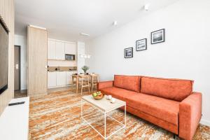 uma sala de estar com um sofá laranja e uma mesa em Rent like home- Elegant Apartments with Balcony em Międzyzdroje