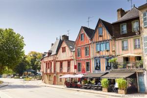 a group of buildings on a street with tables at Confortable appartement aux portes de Vannes in Plescop