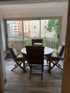 a dining room with a table and chairs and a balcony at STUDIO REFAIT À NEUF BORD DE MER in Six-Fours-les-Plages