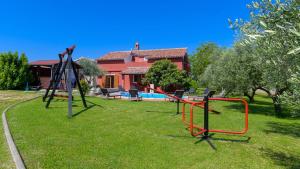 a playground in a yard in front of a house at Charming stone Villa Carla near the sea and town by WiiBuk in Pula
