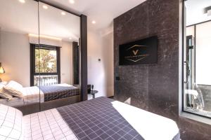 a hotel room with two beds and a window at Vittoria's Luxury Apartment Cagliari in Cagliari