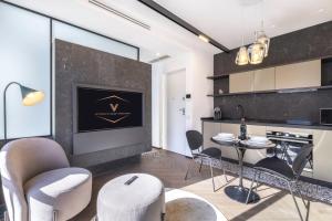 a kitchen and living room with a table and chairs at Vittoria's Luxury Apartment Cagliari in Cagliari