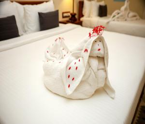 two towels on a bed in a hotel room at Mango Hill La Serene Puducherry in Pūrnānkuppam