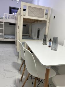 a room with a table and chairs and a bunk bed at Homecation in Dubai