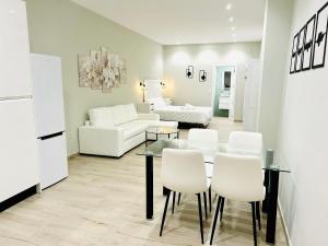 sala de estar con mesa y sillas blancas en RIBERA HOME 2 en Córdoba