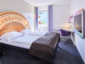 a hotel room with a bed and a desk at B&B Hotel Offenbach-Kaiserlei in Offenbach