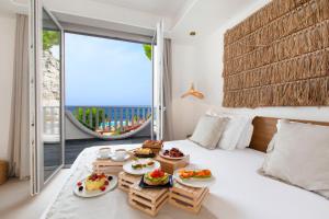 a room with a bed with plates of food on it at Maya Beach Resort in Massa Lubrense